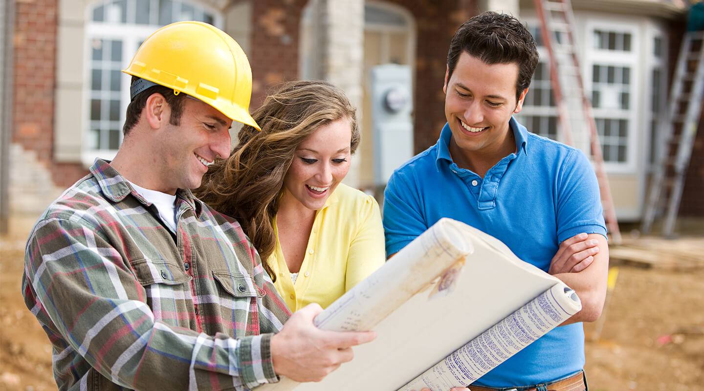 Home builder showing house plans to happy looking couple