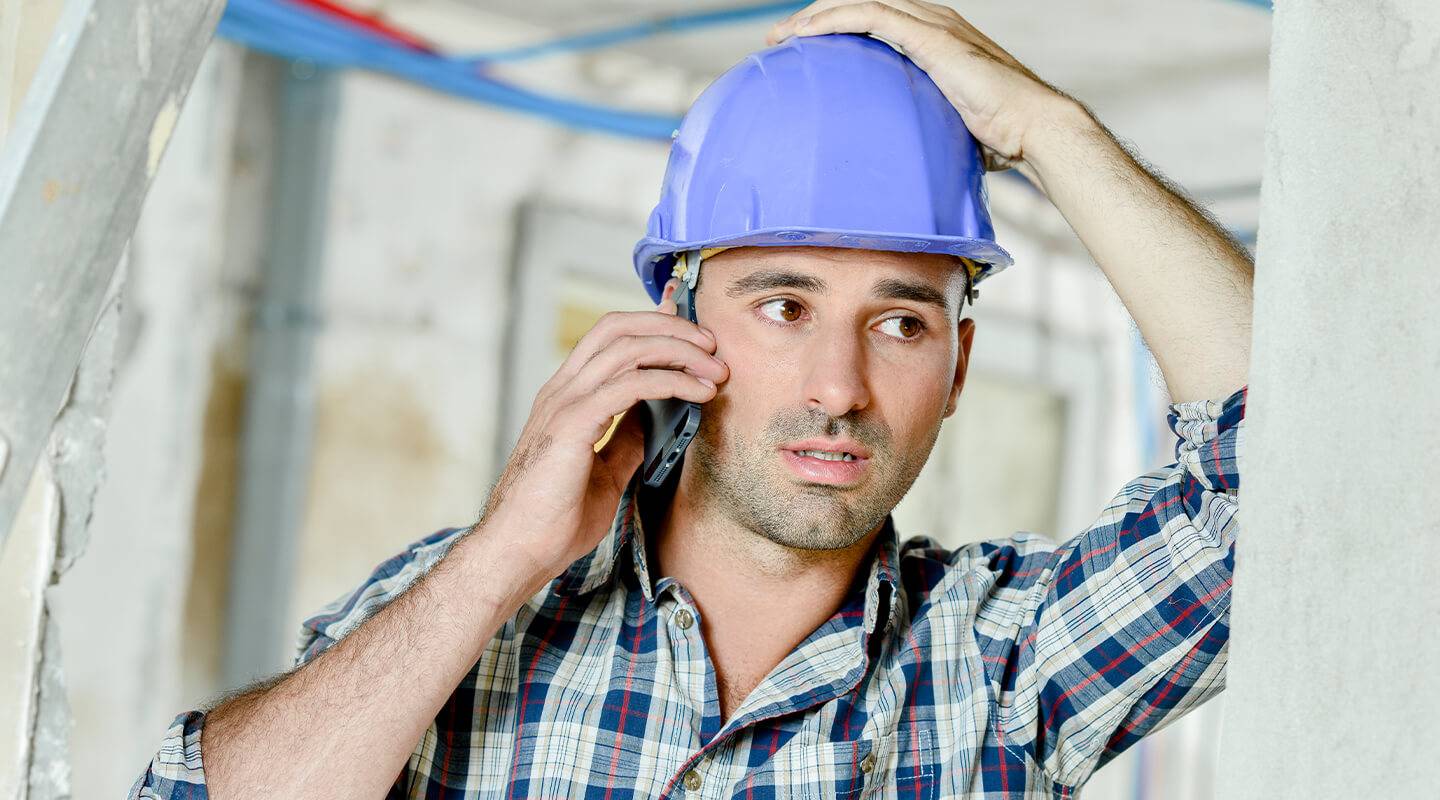 Builder with stressed out look talking over the phone